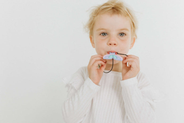 kid being playful with mermaid pendant